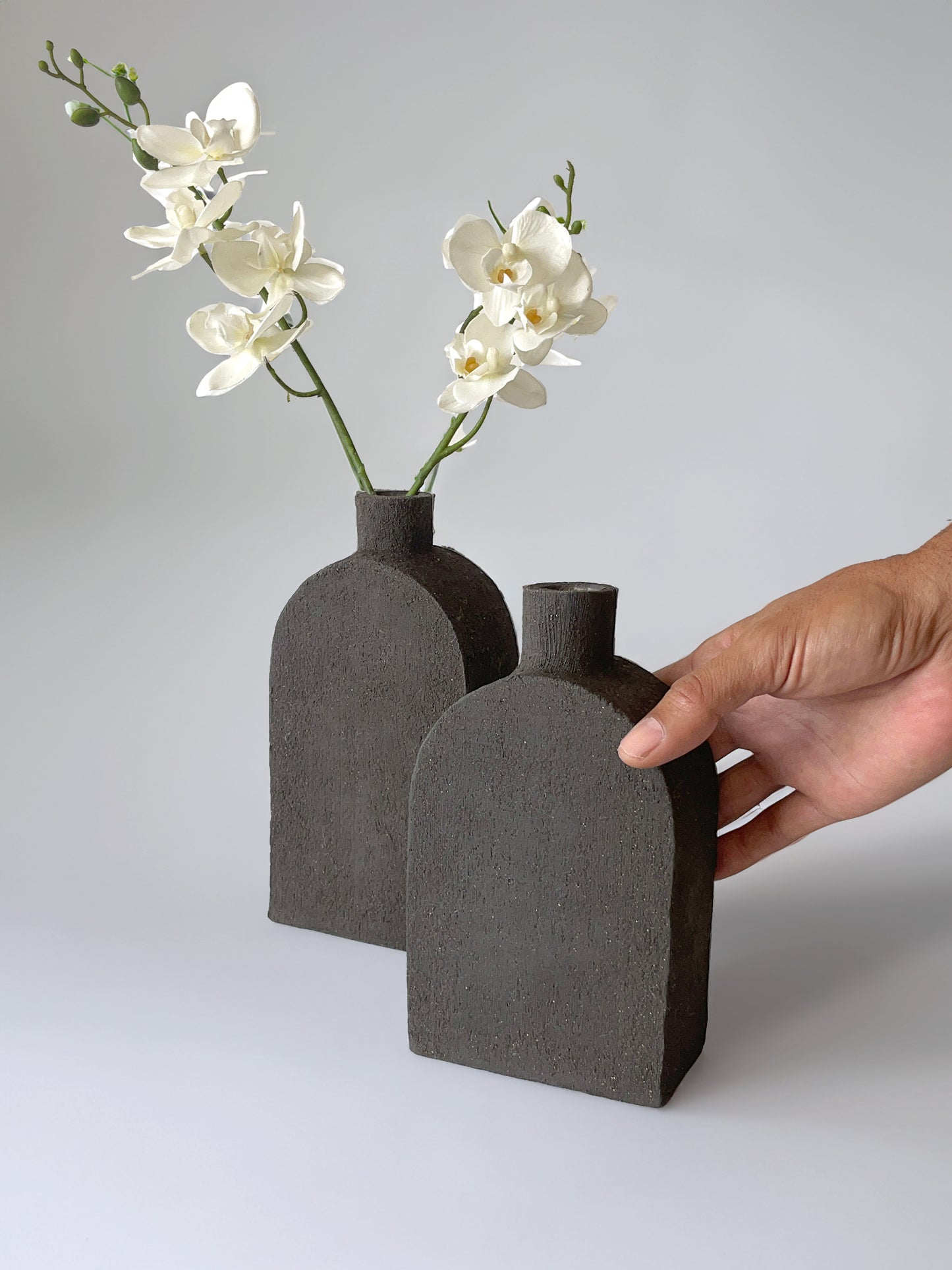 Square bottle-shaped black vase crafted from volcanic-style black clay, adding a touch of sophistication and allure to any space