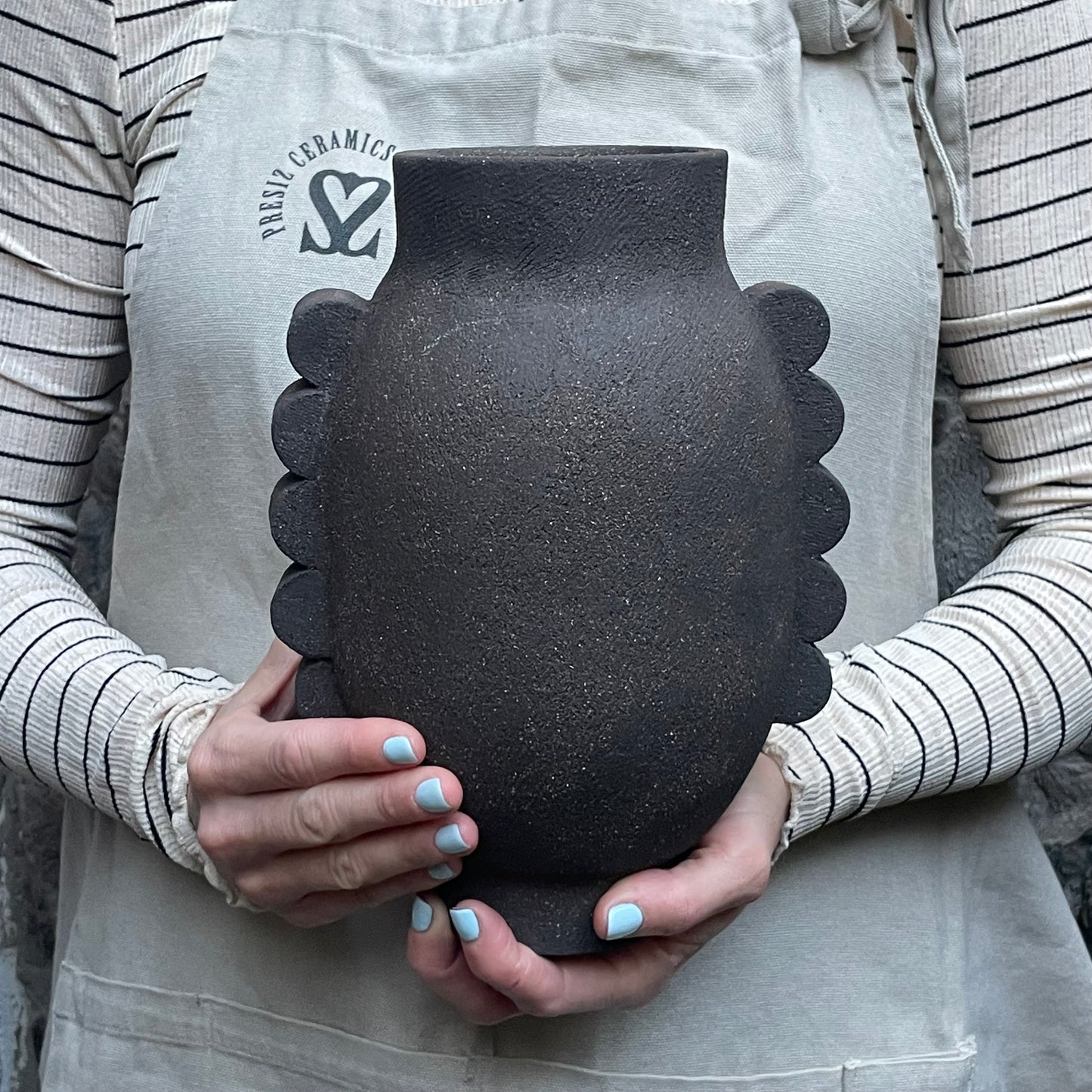 dark vase on hands black pottery