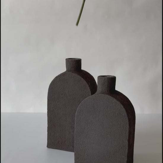 black vase in the shape of a square bottle made of black clay volcanic style black clay