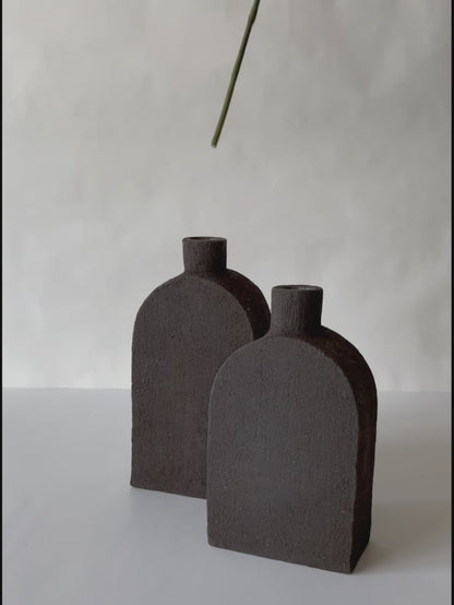 black vase in the shape of a square bottle made of black clay volcanic style black clay