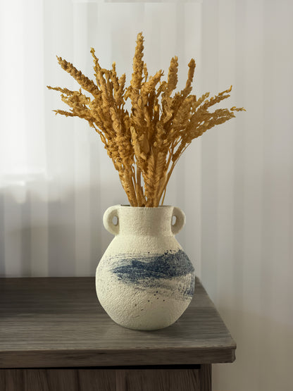 Small white vase adorned with a delicate blue brushstroke at its cente on a table